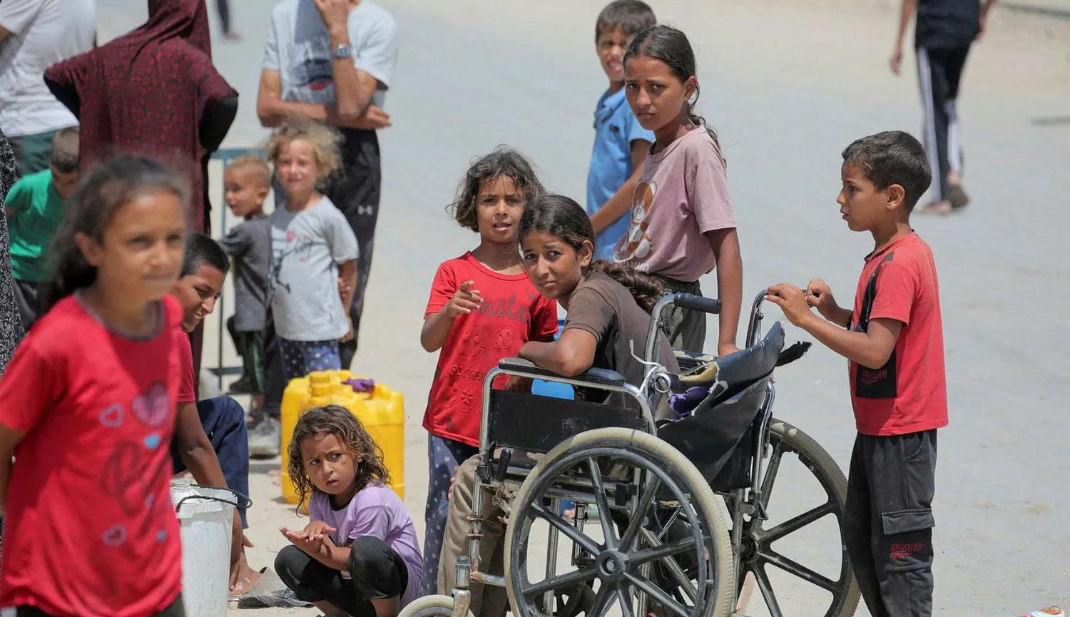 أطفال فلسطينيون في دير البلح ينتظرون دورهم للحصول على مياه  (نقلاً عن "هآرتس")