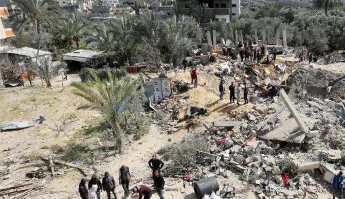 فلسطينيون وسط الدمار الذي خلّفه القصف الإسرائيلي على وسط غزة (نقلاً عن "معاريف")