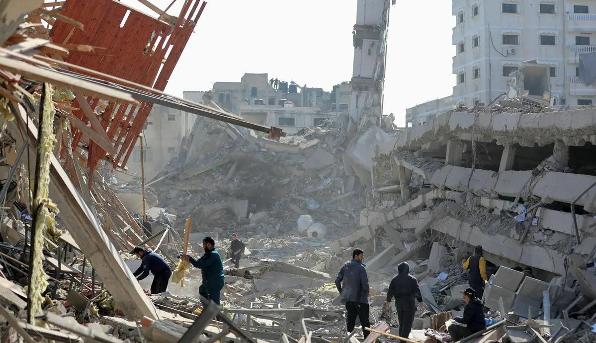 فلسطينيون بين الدمار الذي خلّفه القصف الإسرائيلي على مدينة غزة  (نقلاً عن "هآرتس")