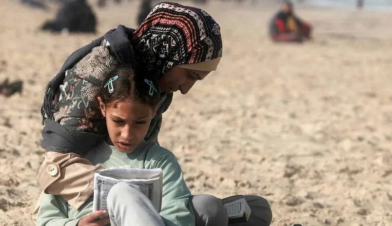 فتاة فلسطينية وأمها على شاطىء غزة  (نقلاً عن "هآرتس")