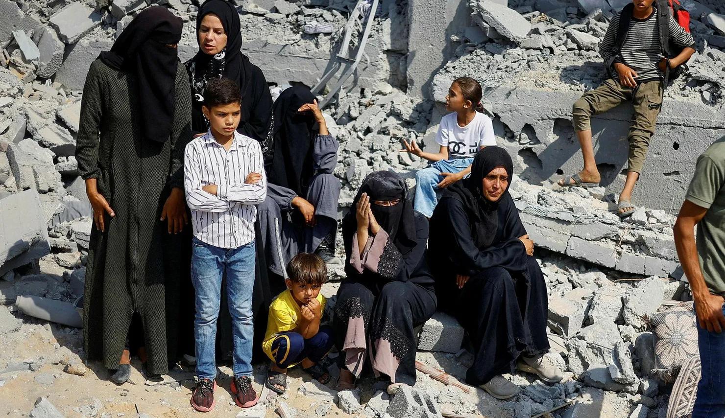 نساء فلسطينيات وأولادهن بين الدمار  الذي خلفه  القصف الإسرائيلي  في خانيونس هذا الأسبوع (نقلاً عن "هآرتس")